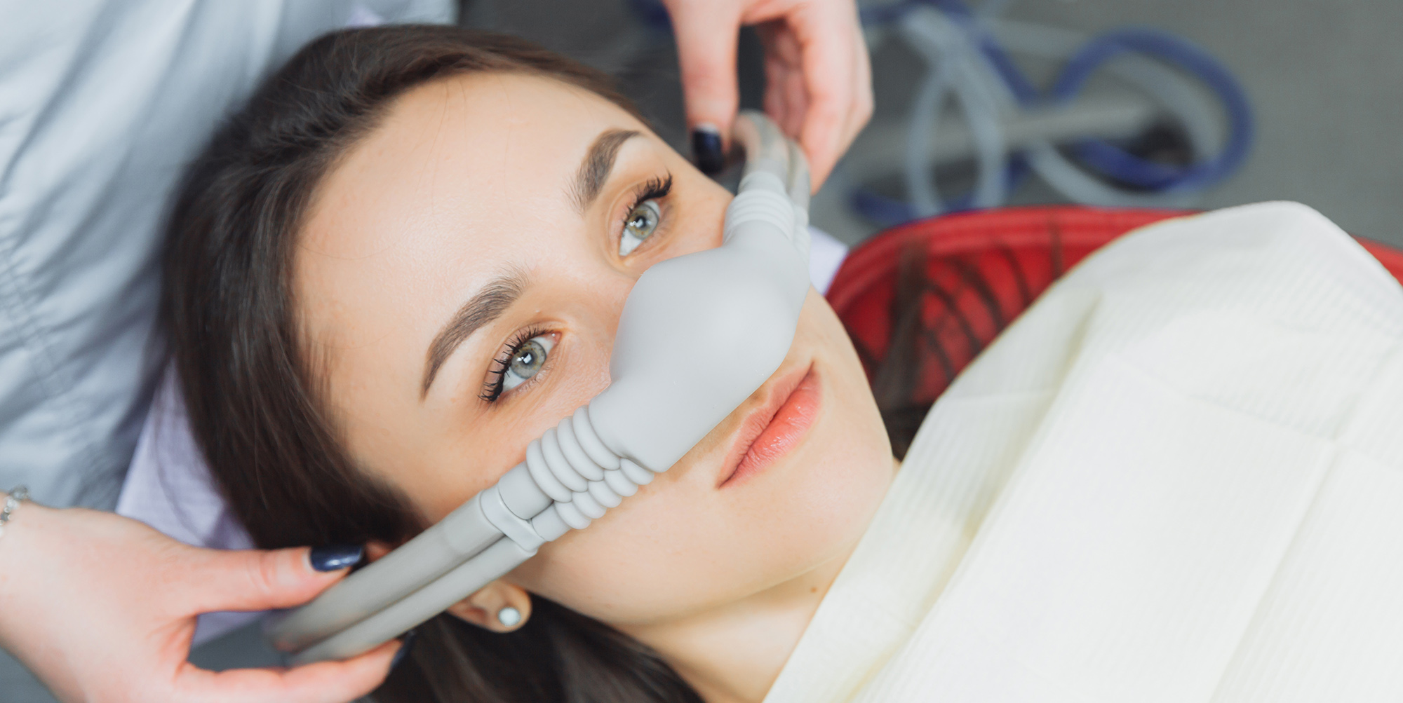 Dentist puts inhalation sedative mask on his patient