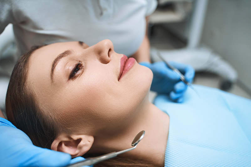 Relaxed young female at dentist under dental sedation