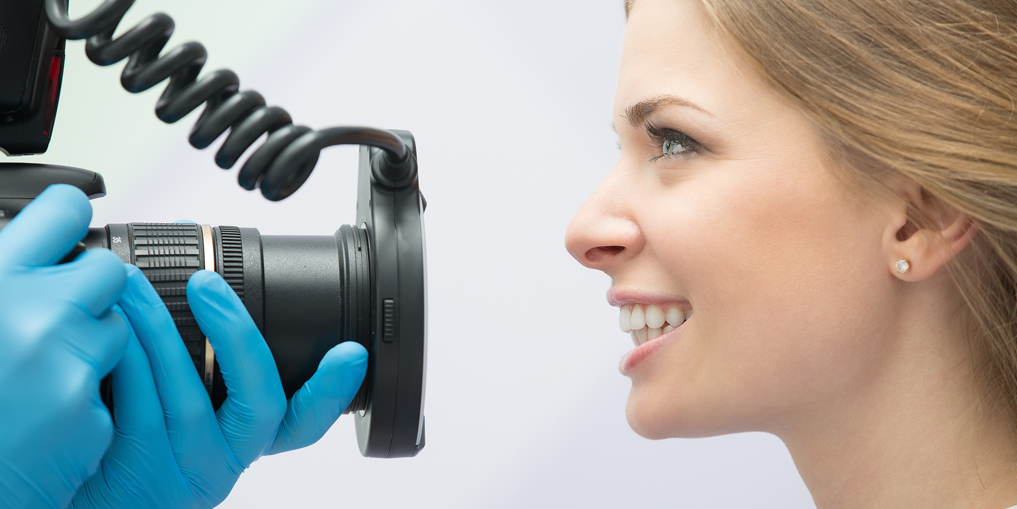 Dentist with a camera photographing a patient for smile design